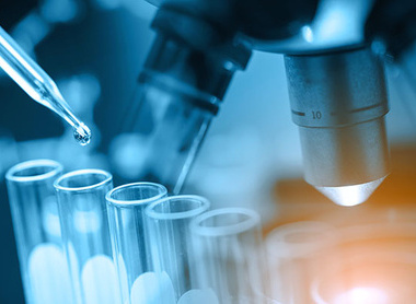 Test vials in front of a microscope
